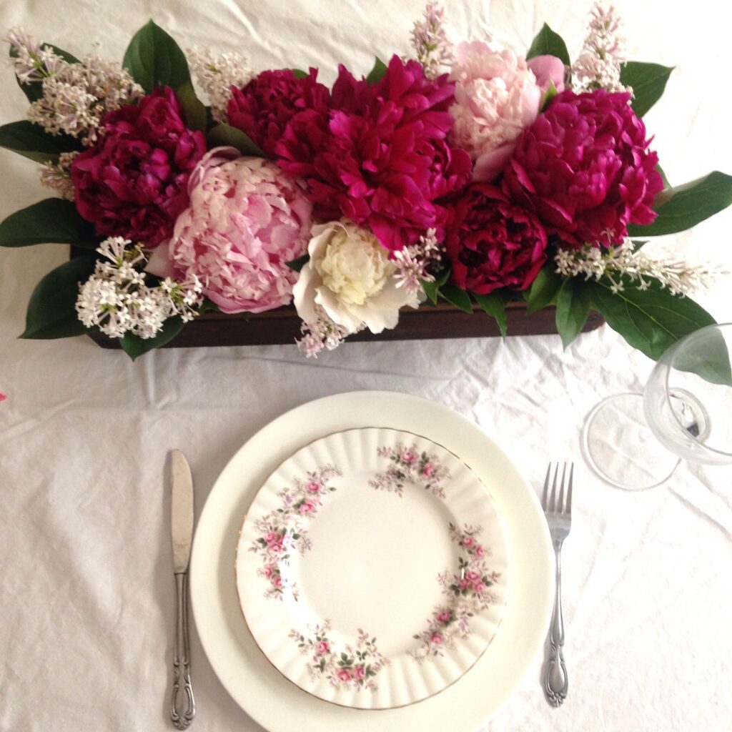 An elegant centrepiece with peonies and lilacs, perfect for a spring wedding or dinner party!