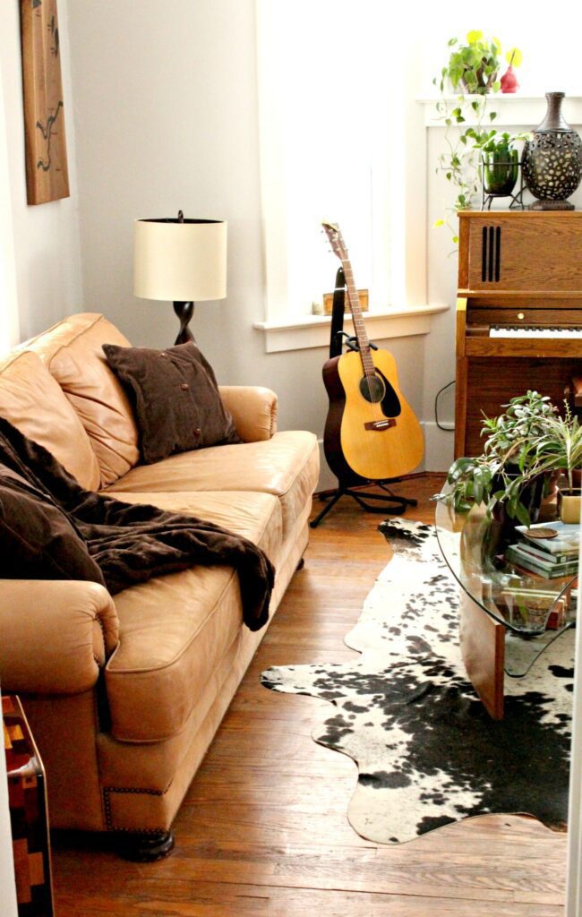 Let's curl up on this cozy brown leather couch and listen to some music. Don't you want this in your music room? #livingroom #musicroom #brownleathercouch #leathercouch #piano #guitar