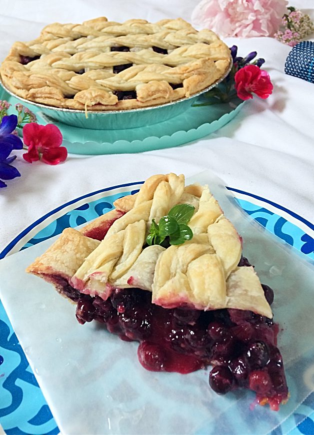 It just isn't summer without a slice of Saskatoon berry pie! This easy dessert recipe has a traditional crust, loads of saskatoon berries (or blueberries) filling, and just a hint of lemon. #saskatoonberries #pie #pierecipe #easydessert #summerdessert #berryrecipe #hardyfruits