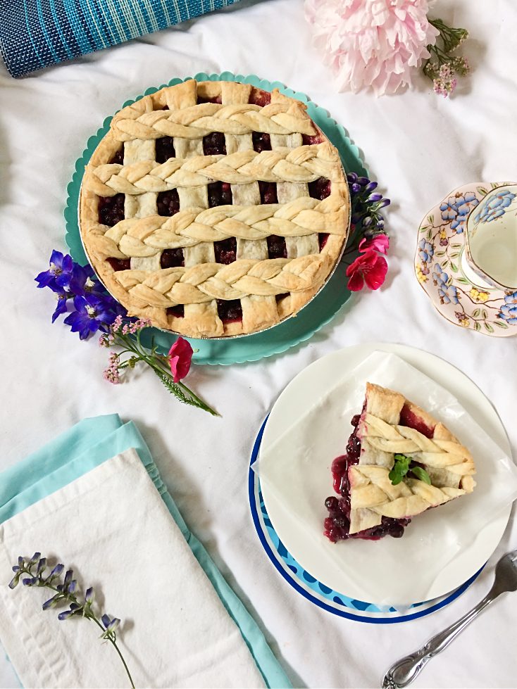 It just isn't summer without a slice of Saskatoon berry pie! This easy dessert recipe has a traditional crust, loads of saskatoon berries (or blueberries) filling, and just a hint of lemon. #saskatoonberries #pie #pierecipe #easydessert #summerdessert #berryrecipe #hardyfruits