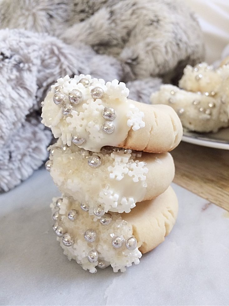 Your Christmas cookie exchange isn't complete without these easy, melt-in-your-mouth shortbread cookies dipped in white chocolate and snowflake sprinkles. Make a double batch, because the soft and buttery taste will have everybody coming back for more! #shortbread #cookies #Christmas #baking