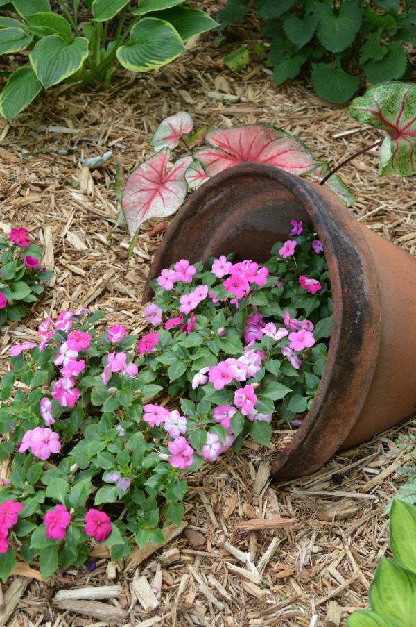 I think whimsical garden art really makes a backyard flower bed.  I love these 20 diy ideas that are either recylcled, upcylcled, or from junk that nobody wants.  I need to do some of these in my outdoor space--what a neat way to use a broken pot. #gardenart #whimsical #flowergarden #landscapingideas