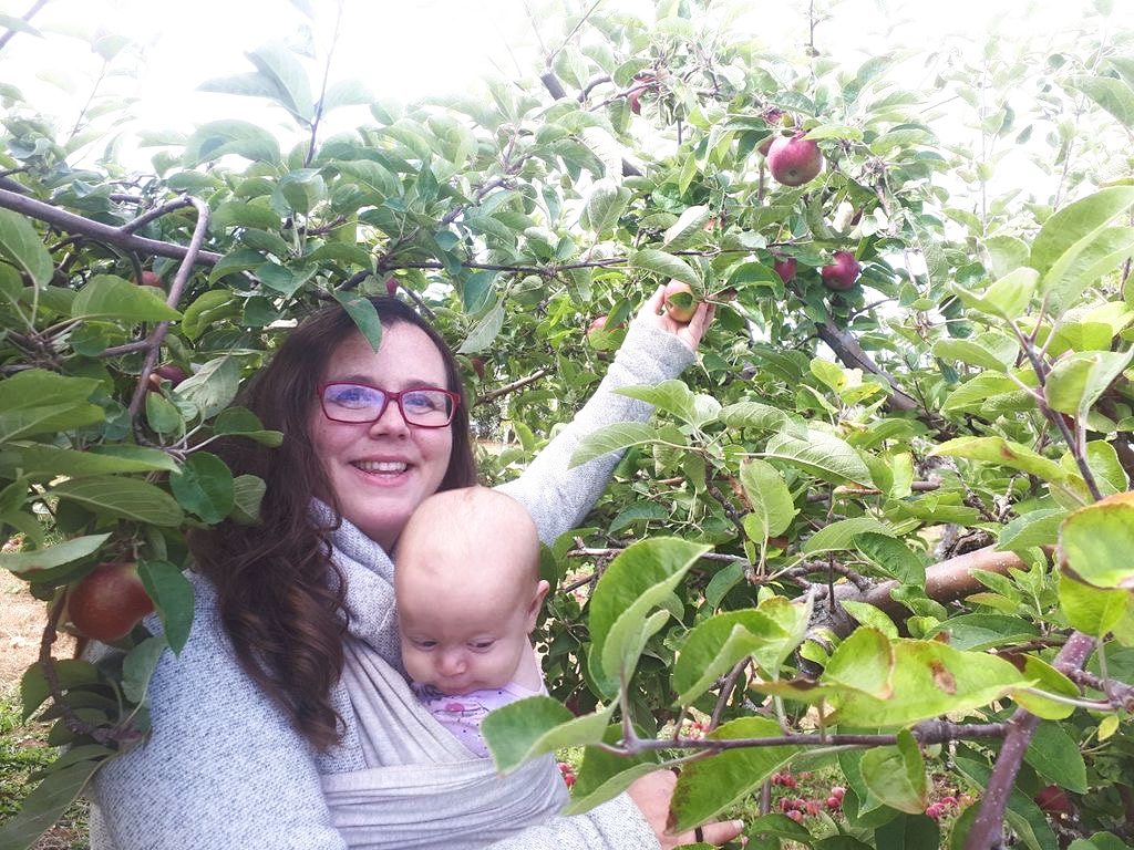 woman with baby in apple tree