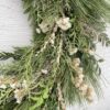 Detail of snow queen wreath, showing evergreens, statice, cress, and cloud grass