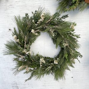 Evergreen wreath with dried flowers in neutral tones
